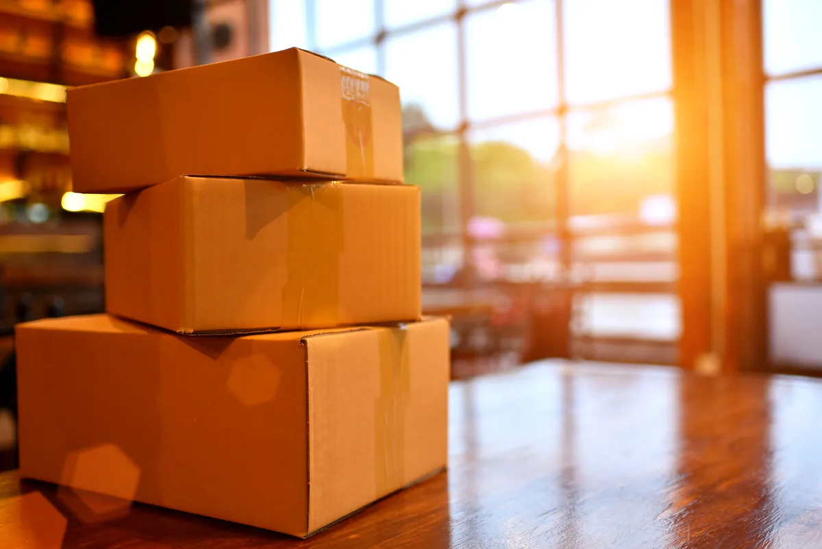 E-ticaret nasıl yapılır sorusu için ürün, kargo kutuları ve satış planının yer aldığı çalışma masası